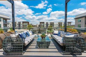 沃思堡Elegant & Luxurious Modern Apartment with Southern Charm的阳台的天井配有沙发和桌子。