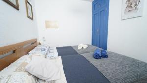 阿尔姆尼卡Apartamento Brisa Del Mar的一间卧室配有一张带蓝色拖鞋的床。
