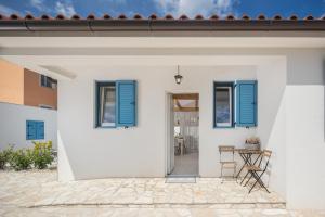 佩罗杰Spacious holiday house in Istria的白色的房子,设有蓝色百叶窗和庭院