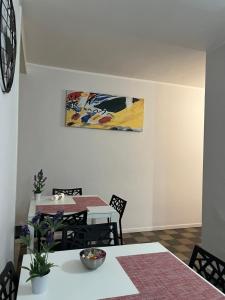 卡塔尼亚Antica Dimora Maravigna的用餐室配有桌椅和墙上的绘画作品