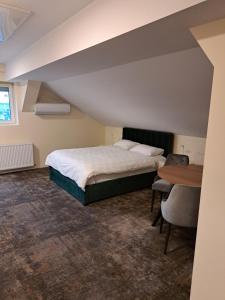 奥拉迪亚Casa Livia PP Aparthotel的一间卧室配有一张床和一张木桌