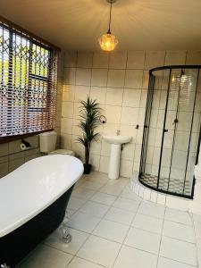 比勒陀利亚Botlhale Guesthouse, Events & Spa的带浴缸、卫生间和盥洗盆的浴室