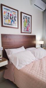 彼得罗利纳Sofisticado, NOVO e Moderno!的卧室内的一张床铺,墙上有两张照片