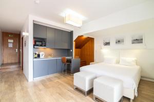 卡罗拉ANC Resort的一间带白色床的卧室和一间厨房