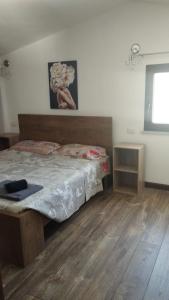 托里格兰德casa vacanza Il Delfino的一间卧室配有一张床,铺有木地板