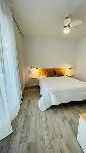 巴达霍斯Apartamentos BRAVO MURILLO con garaje en centro histórico的卧室配有一张白色的大床,铺有木地板