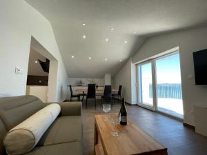 穆泰尔岛BEACHFRONT VILLA Murter的客厅配有沙发和带酒杯的桌子