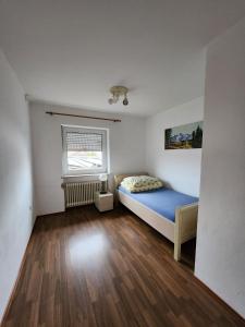 Töging am InnStadthostel的一间设有蓝色床和窗户的小卧室