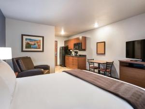 西乔丹My Place Hotel-Salt Lake City-West Jordan的配有一张床和一台平面电视的酒店客房