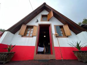 桑塔纳Abrigo da Serra- Nature Trails的红色和白色的房子,有红色的门