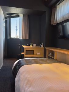 东京FL酒店 浅草東上野的一间卧室配有一张床,窗户带有塔楼