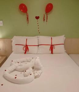 巴雷里尼亚斯Gran Lençóis Flat Residence的墙上有红色心和气球的床
