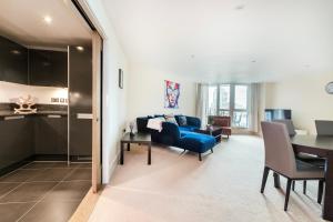 伦敦Modern 2 Bedroom 2 Bath Apartment with River View的客厅配有蓝色的沙发和桌子