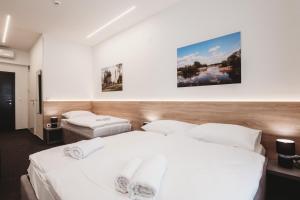 奥西耶克Bells Osijek的配有白色床单的酒店客房内的两张床