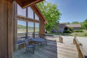 芒廷维尤Roomy Riverfront Trout Valley Cabin with Porch!的房屋内带桌椅的木制甲板