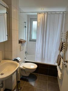 卡塞尔Steinweg 7 Ferienwohnung的浴室配有卫生间、浴缸和水槽。