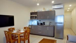 棕榈滩Arena Condominium Aruba的厨房配有桌子和不锈钢冰箱。