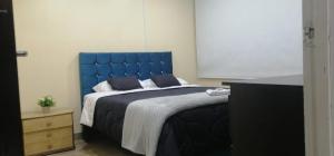 波哥大Roma Lodges House - Turin- Campin Movistar Embajada cubo colsubsidio的卧室里一张带蓝色床头板的床