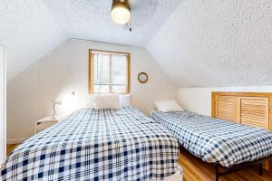 康威Rockhouse Mountain Retreat的一间卧室设有两张床和窗户。