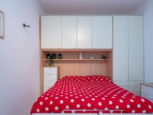 米兰I Host Apartment - San Faustino 78的一间卧室配有一张红色的床和白色的橱柜