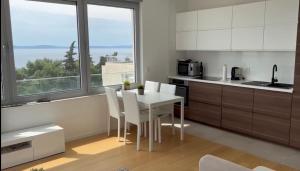 斯普利特Splendid Split View apartment的厨房配有白色的桌子和白色的椅子
