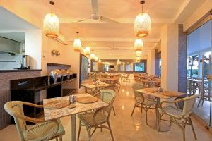卡塔赫纳海滨夏日酒店的一间带桌椅的餐厅和一间酒吧