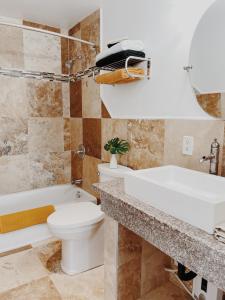 Honomu霍诺姆宾馆的浴室配有卫生间、盥洗盆和浴缸。