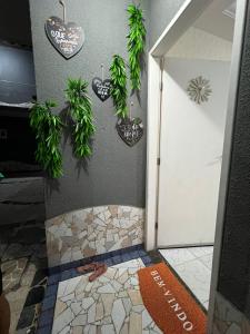 阿拉卡茹Casa temporada Aracaju的墙上设有植物淋浴的浴室