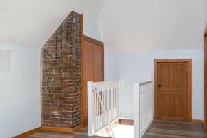 盖恩斯维尔Spacious Family Friendly Retreat 3 BD Loft的砖墙和木门的楼梯