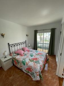 蒂亚斯Casa Princesa的一间卧室配有带粉红色枕头的床和窗户。