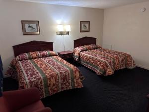 塔尔萨CRYSTAL MOTEL的酒店客房,配有两张床和椅子