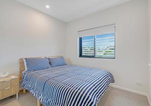 黄金海岸Sunny Gold Coast Miami Getaway的一间卧室配有条纹床和窗户