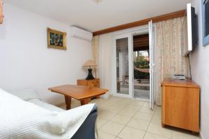 奥米什Apartments and rooms by the sea Nemira, Omis - 2781的一间卧室配有一张床、一张桌子和一个窗户。