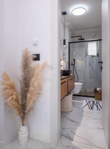 米利尼Blue Ivy的浴室设有卫生间和带羽毛的花瓶。