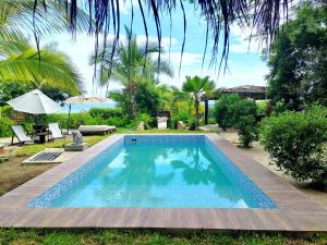 洛斯拉甘斯El Mirador de Punta Veleros的庭院内的游泳池,配有桌子和遮阳伞