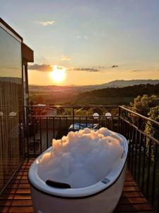 波苏阿莱格里Tiny House Paraiso Minicasas Com Hidromassagem的浴缸位于阳台,享有日落美景。