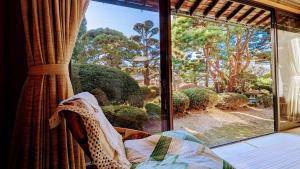 富士吉田市富士吉田かつまたや的客房设有一个窗户,享有花园的景色