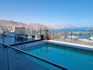 安托法加斯塔Antofagasta de Lujo的一座游泳池位于一座享有海景的建筑的顶部
