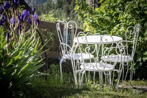 托尔诺托尔诺罗威尔德滋旅馆的花园内提供两把白色椅子和一张桌子