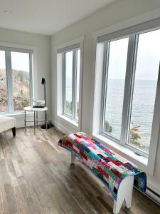 Pilleyʼs IslandThe View suites and breakfast in Triton, Newfoundland的一间卧室设有窗户和一张带彩色毯子的床。