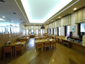 札幌札幌奇塔约行程酒店的餐厅设有木桌、椅子和窗户。