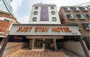 首尔Just Stay Hotel的在大楼前的一张酒店标志