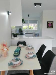 奥克兰Centre Takapuna 2 Beds & Garage & Netflix的白色的厨房,配有桌子和四盘盘