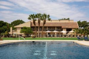 伯尼Tapatio Springs Hill Country Resort的一座带游泳池的度假村,位于一座建筑前