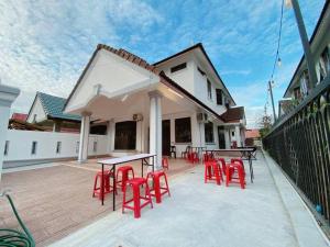 马西C01 Budget Homestay in Tmn Rinting的庭院里一套红色的桌椅