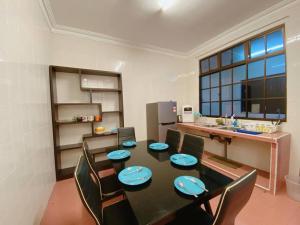 马西C01 Budget Homestay in Tmn Rinting的一间带桌椅的用餐室和一间厨房