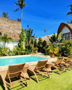 卢纳将军城Tropical Temple Siargao Resort的一组椅子坐在游泳池旁