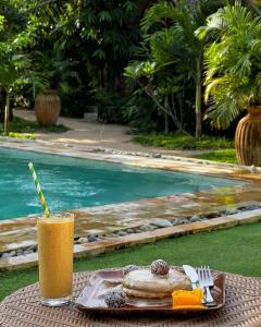 卢纳将军城Tropical Temple Siargao Resort的池畔的饮料和一盘食物