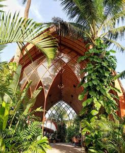 卢纳将军城Tropical Temple Siargao Resort的一座有一束植物和一棵棕榈树的建筑