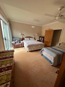 旺阿雷Tamaterau Seaview House in Whangarei的一间卧室配有两张床和吊扇